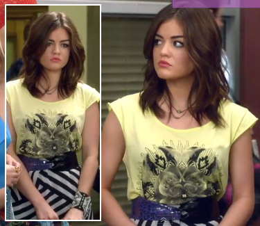 Aria's black and white striped skirt with yellow graphic print top and purple belt on Pretty Little Liars