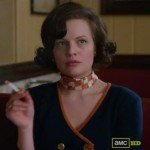 Peggy’s navy sweater with orange trim and orange scarf on Mad Men