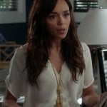 Ashley’s white v-neck blouse and gold knot and tassle necklace on Revenge