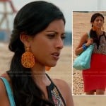 Divya’s orange statement earrings, tribal print cutout top and red high waisted skirt on Royal Pains