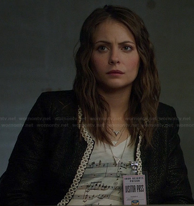 Thea's musical notes print t-shirt and black jacket with white trim on Arrow