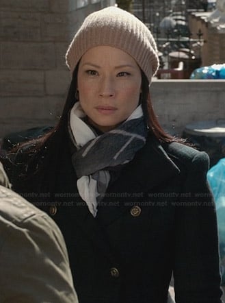 Joan's green plaid coat and beige ribbed beanie on Elementary