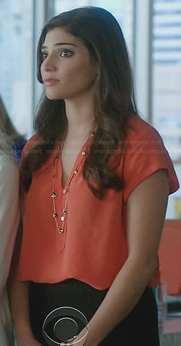 Lauren’s orange blouse and black strand necklace on The Crazy Ones
