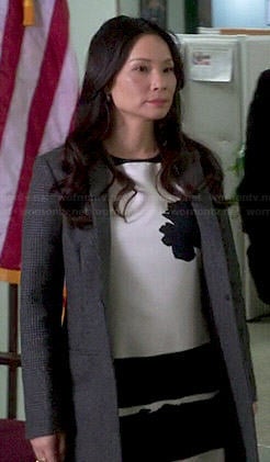 Joan's black and white flower and stripe dress and grey coat on Elementary