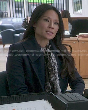 Joan’s navy coat and black and white printed scarf on Elementary