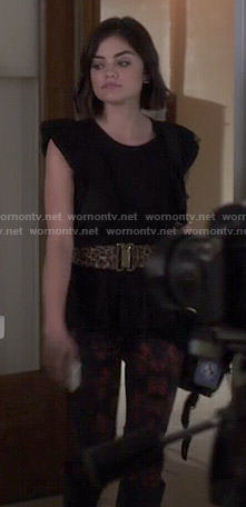 Aria's black ruffled top and rose print jeans on Pretty Little Liars