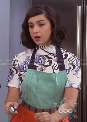Mandy's printed mock-neck top and mint/orange apron on Last Man Standing