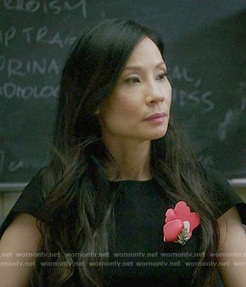 Joan's black dress with red brooch on Elementary