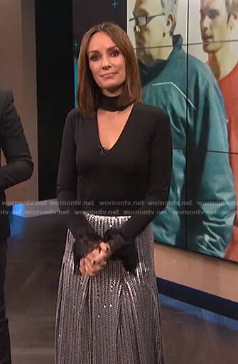 Catt’s black choker neck top with lace cuffs and sequin pleated skirt on E! News