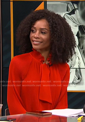 Zuri’s red pleated tie neck blouse on Live from E!