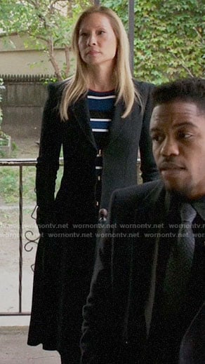 Joan's blue striped top and long black coat on Elementary