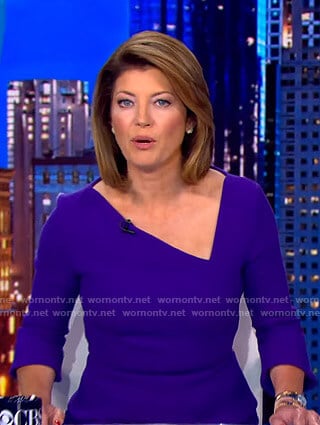 Norah’s blue asymmetric v-neck dress on CBS Evening News