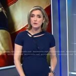 Margaret’s blue twisted neckline dress on CBS Evening News