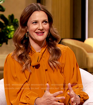 Drew’s orange tie neck blouse on The Drew Barrymore Show