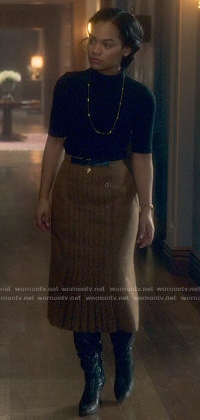 Rebecca’s black top and pleated camel skirt on The Haunting of Bly Manor