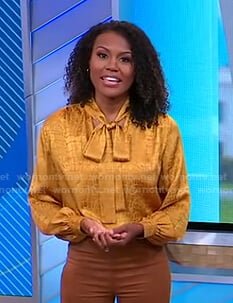 Janai’s yellow crocodile print tie neck blouse on Good Morning America