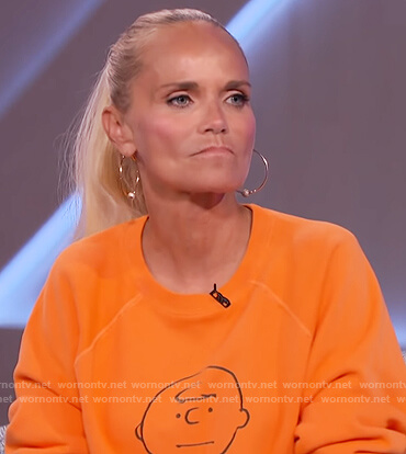 Kristin Chenoweth’s orange Charlie Brown print sweater on The Kelly Clarkson Show