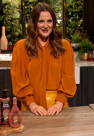 Drew’s orange tie neck blouse and sequin skirt on The Drew Barrymore Show