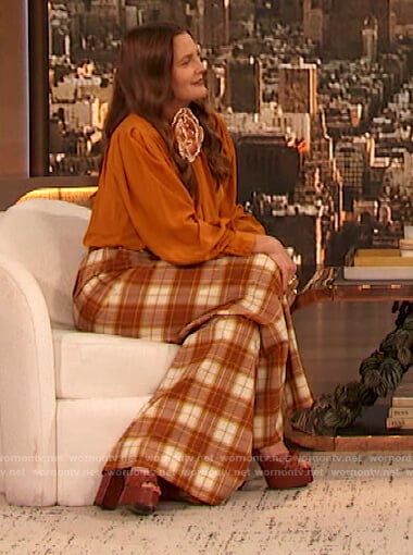 Drew’s orange tie neck blouse and plaid pants on The Drew Barrymore Show