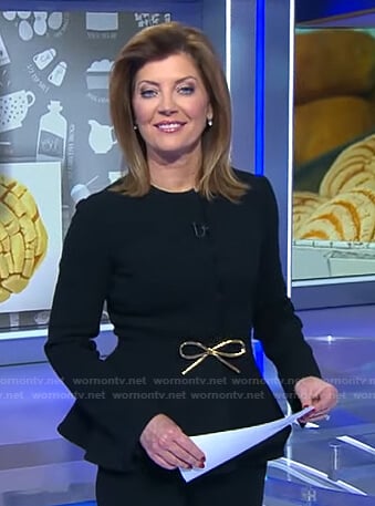 Norah’s black peplum jacket with bow belt on CBS Evening News