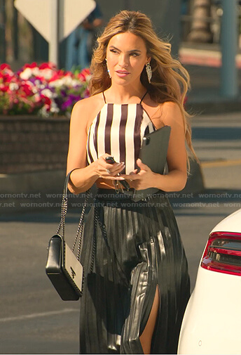 Chrishell’s black striped top and pleated leather skirt on Selling Sunset