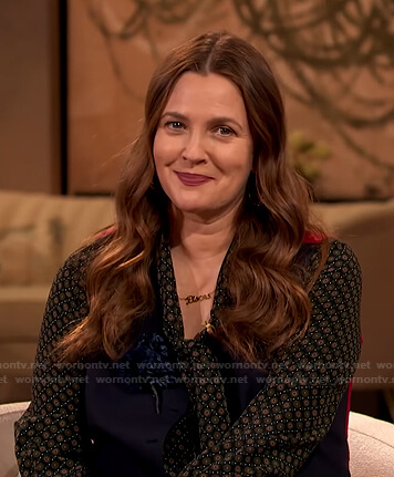 Drew’s black printed tie neck blouse and beige pants on The Drew Barrymore Show