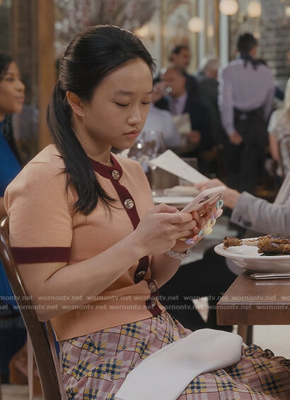 Lily’s orange contrast trim cardigan and plaid skirt on And Just Like That