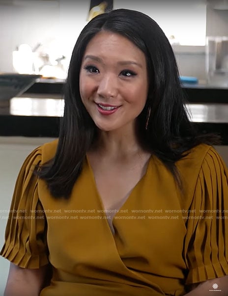 Nancy Chen’s mustard yellow pleated wrap dress on CBS Mornings