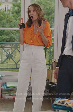 Sylvie’s orange blouse and white high waist pants on Emily in Paris