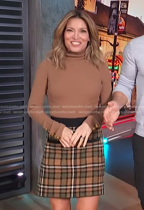 Kit’s brown turtleneck top and plaid skirt on Access Hollywood
