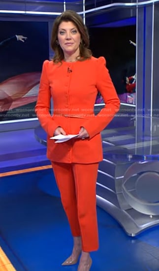 Norah’s orange belted jacket and cropped pants on CBS Evening News