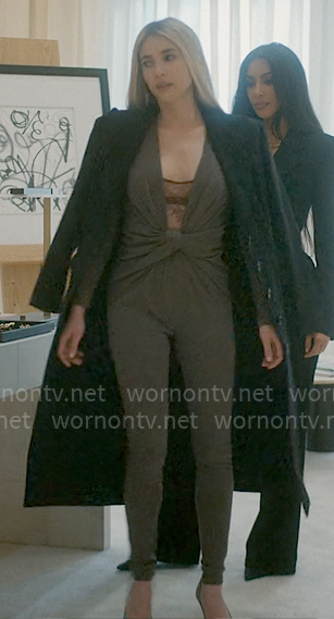 Anna's grey twist front jumpsuit, lace bodysuit, silver clutch, and black coat on American Horror Story