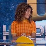 Christina’s orange patterned sweater and purple geometric skirt on The Morning Show