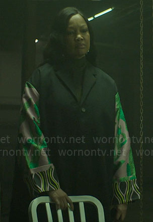Diana's black coat with printed sleeves on The Other Black Girl