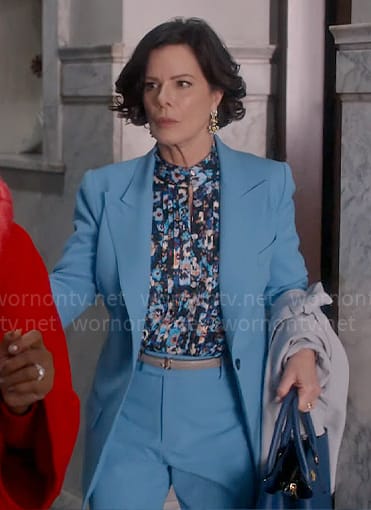 Margaret’s floral pleated blouse and blue suit on So Help Me Todd