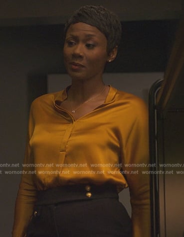 Jax's gold satin blouse on Reasonable Doubt