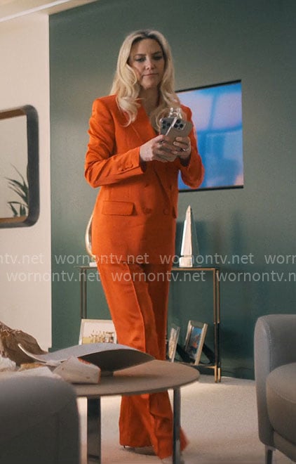 Isla's orange satin suit on Running Point