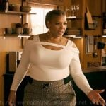 Robyn’s white cutout shoulder sweater and monogram print pants on The Equalizer