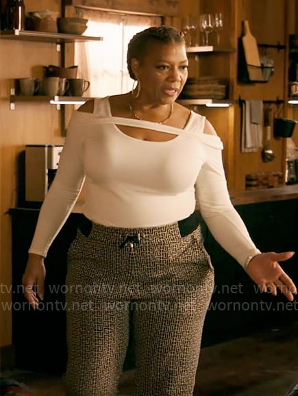 Robyn's white cutout shoulder sweater and monogram print pants on The Equalizer