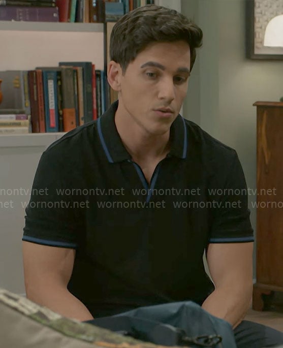 Smitty’s black polo shirt with blue trims on Beyond the Gates