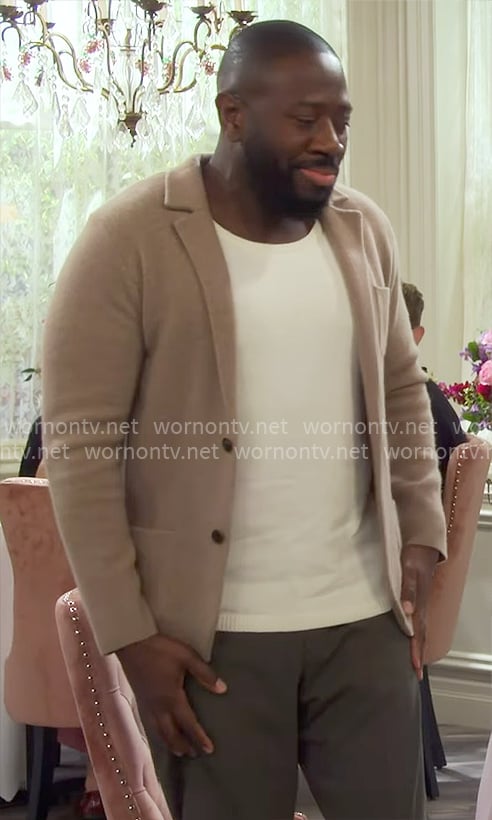 Malcolm’s beige knit jacket on The Neighborhood