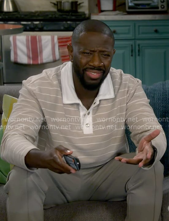 Malcolm's light beige striped polo shirt on The Neighborhood