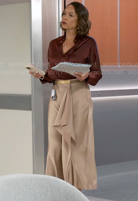 Nicole’s dark red button down blouse and beige draped skirt on Beyond the Gates