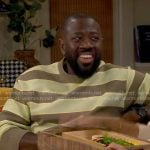 Malcolm's green and brown striped sweater on The Neighborhood
