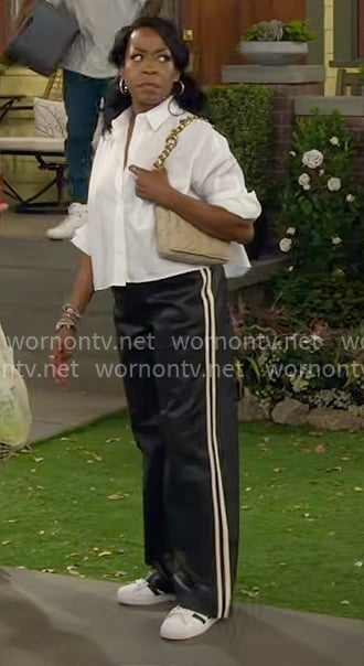 Tina's white cropped shirt and faux leather track pants on The Neighborhood